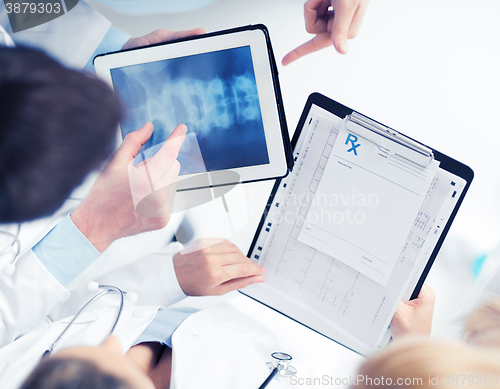 Image of group of doctors looking at x-ray on tablet pc