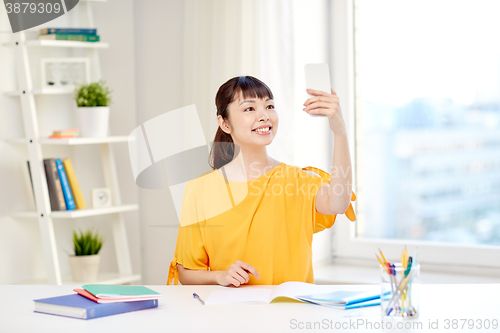 Image of asian woman student taking selfie with smartphone