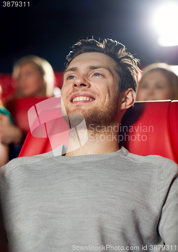 Image of happy young man watching movie in theater