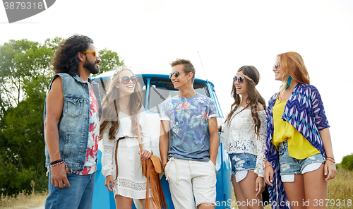 Image of smiling young hippie friends over minivan car