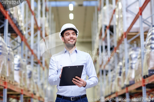 Image of happy businessman with clipboard at warehouse