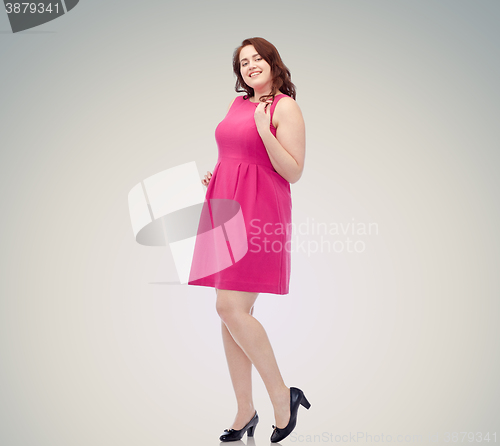 Image of happy young plus size woman posing in pink dress