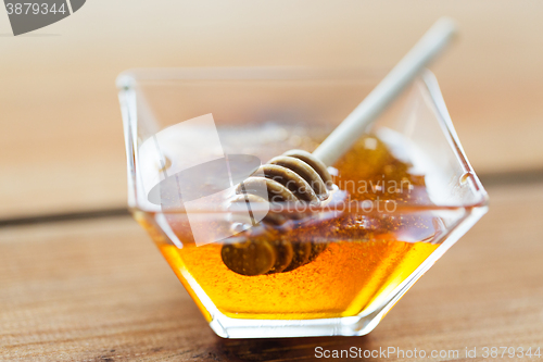 Image of close up of honey in glass bowl and dipper