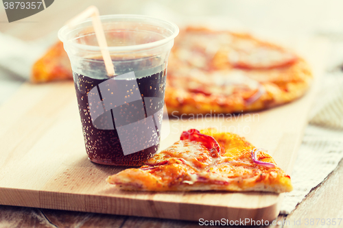 Image of close up of pizza with coca cola on table