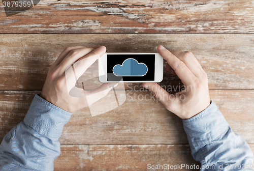 Image of close up of male hands with cloud on smartphone