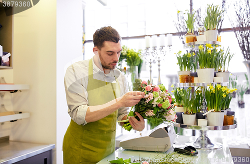 Image of florist man making bunch at flower shop