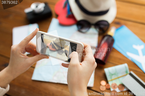 Image of close up of woman with smartphone and travel stuff