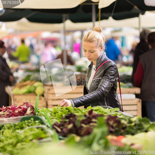 Image of Woman buying vegetable at local food market. 