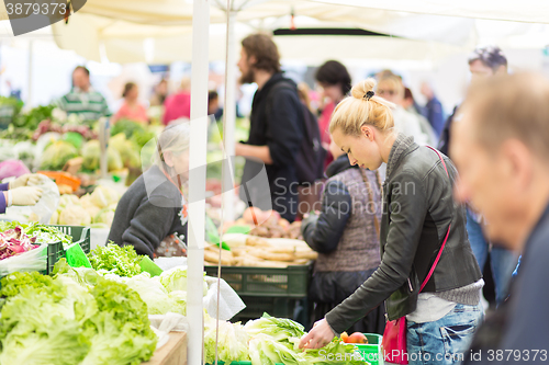 Image of Woman buying vegetable at local food market. 