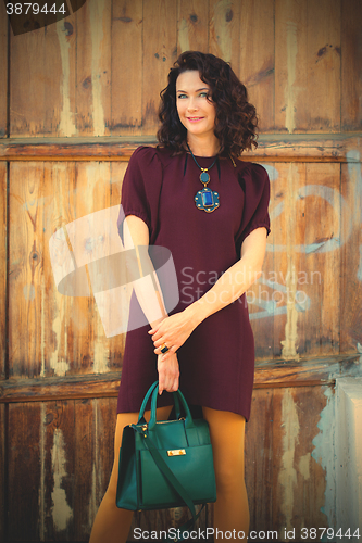 Image of beautiful middle-aged woman in a burgundy dress 