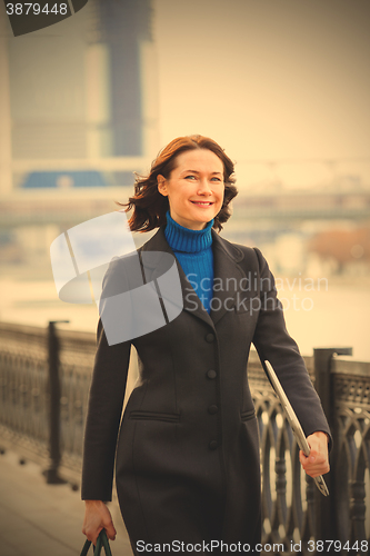 Image of smiling middle-aged woman in a dark coat