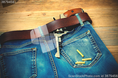 Image of revolver in his leather belt