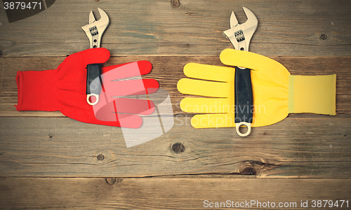 Image of protective gloves with pipe wrench