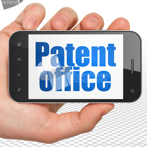 Image of Law concept: Hand Holding Smartphone with Patent Office on display