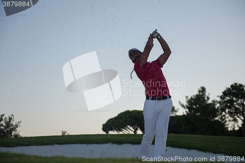 Image of golfer hitting a sand bunker shot on sunset