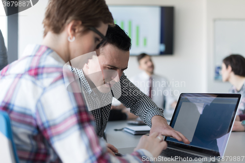 Image of young business couple working on laptop, businesspeople group on
