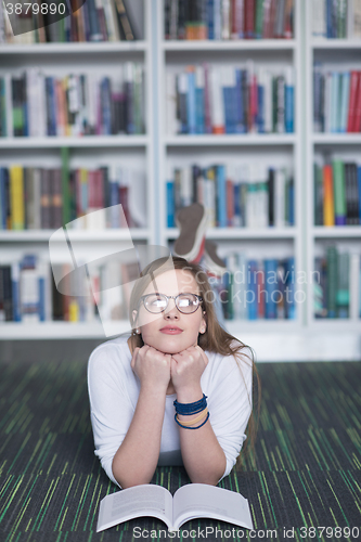 Image of female student study in library, using tablet and searching for 