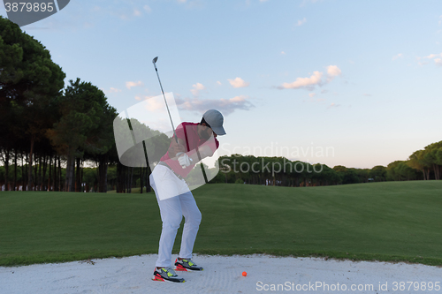 Image of golfer hitting a sand bunker shot on sunset