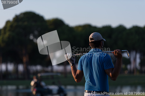 Image of golfer from back at course looking to hole in distance