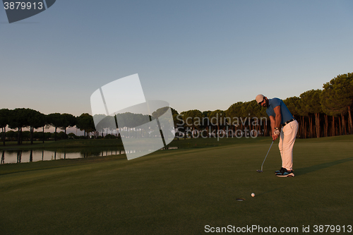 Image of golfer  hitting shot at golf course