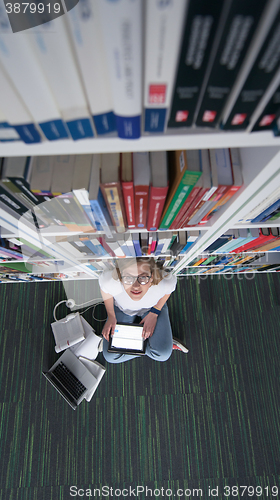 Image of female student study in library, using tablet and searching for 