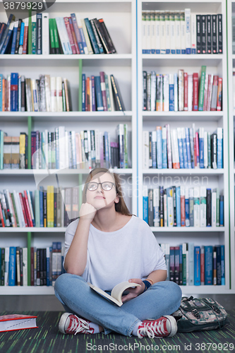 Image of famale student reading book in library