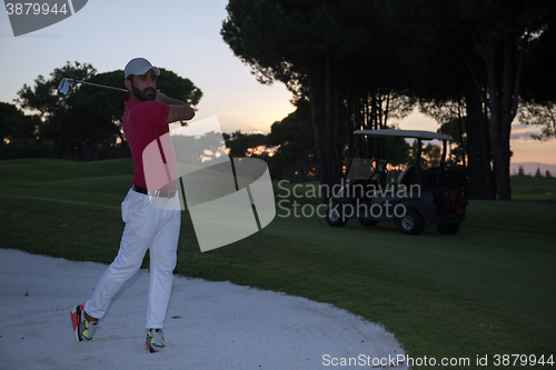 Image of golfer hitting a sand bunker shot on sunset