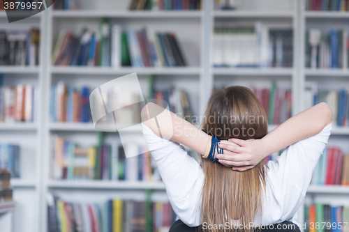 Image of female student study in library, using tablet and searching for 