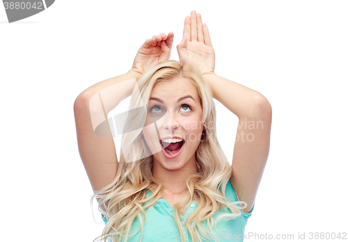 Image of happy smiling young woman making bunny ears