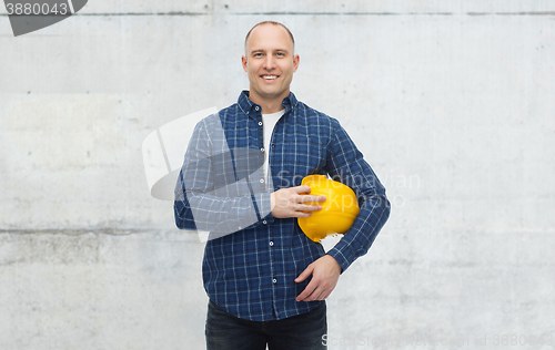 Image of smiling man with helmet over concrete wall