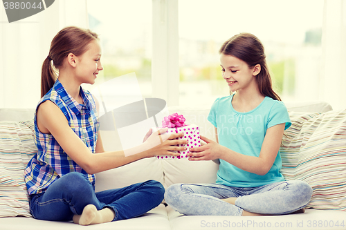 Image of happy little girls with birthday present at home