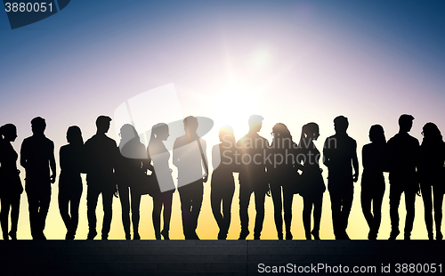 Image of silhouettes of students on stairs over sun