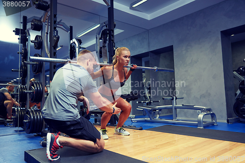 Image of man and woman with bar flexing muscles in gym