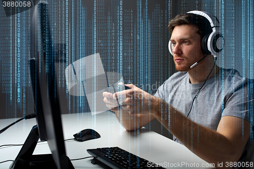 Image of man in headset playing computer video game at home