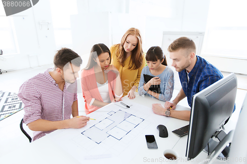 Image of creative team with blueprint working at office