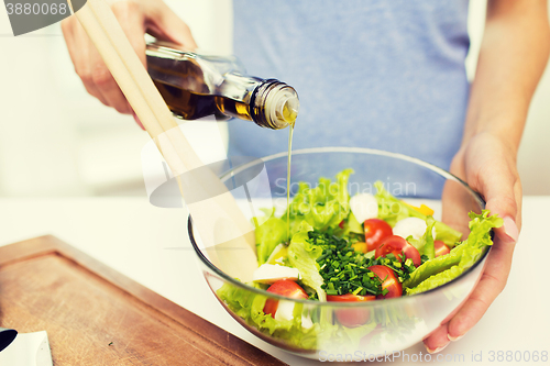 Image of close up of woman cooking vegetable salad at home