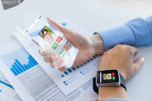 Image of close up of hands with smart phone and watch