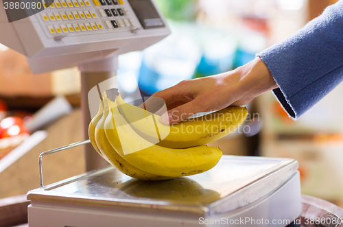 Image of close up of woman hand with banana scales at shop