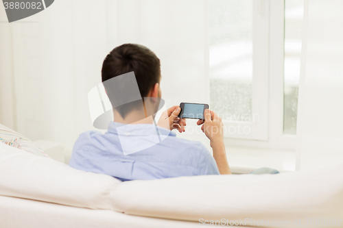 Image of close up of man with smartphone at home
