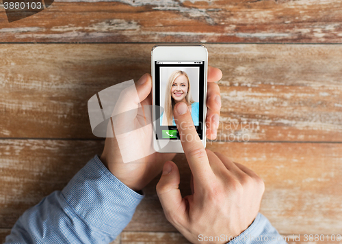 Image of close up of hands with incoming call on smartphone