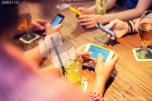 Image of close up of hands with smartphones at restaurant