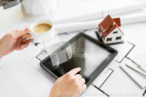 Image of close up of hand with blueprint and tablet pc