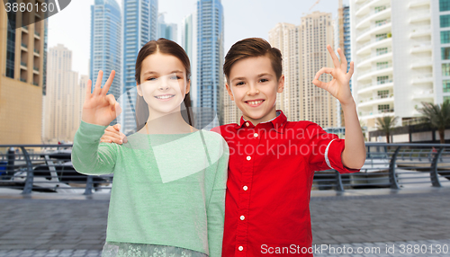 Image of happy boy and girl showing ok hand sign