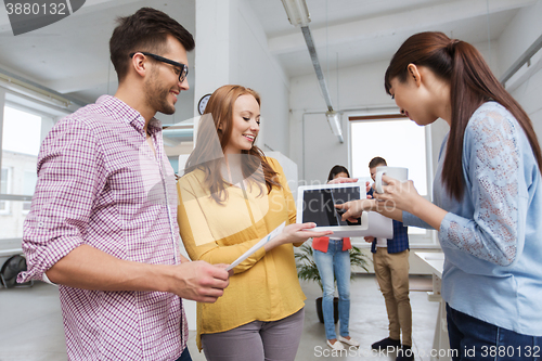 Image of creative team with tablet pc talking at office