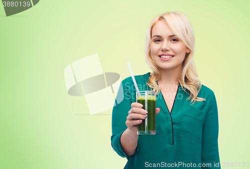 Image of smiling woman drinking vegetable juice or smoothie