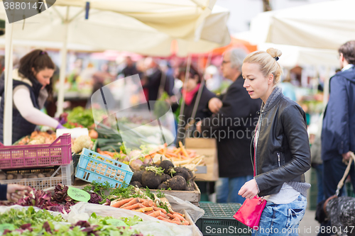 Image of Woman buying vegetable at local food market. 