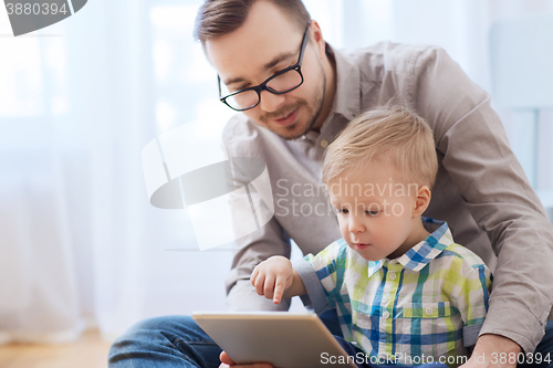 Image of father and son with tablet pc playing at home