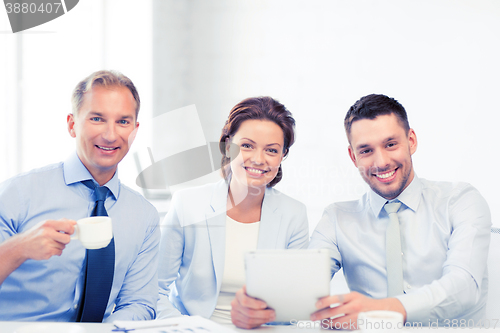 Image of business team having fun with tablet pc in office