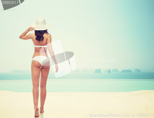 Image of young woman in white bikini swimsuit from back