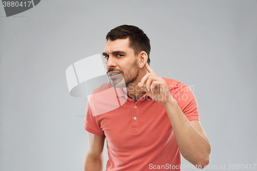 Image of man having hearing problem listening to something